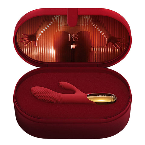 A red silicone intimate massager with a gold-toned base, displayed inside an open matching red presentation case on a white background.