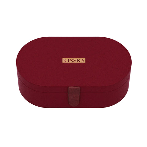 A dark red oval-shaped jewelry box with a small gold metal plaque on the front that reads 'KISSKY' and a matching dark red leather strap closure, shown on a clean white background.