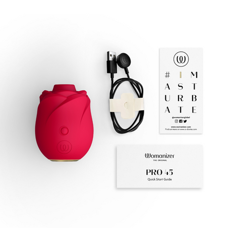 Red device with black attachments and a 'Womanizer' branded card on a white background
