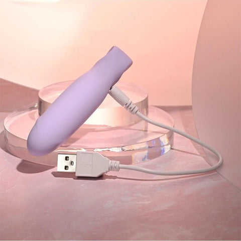 Purple electronic device with a USB cable on a pink surface